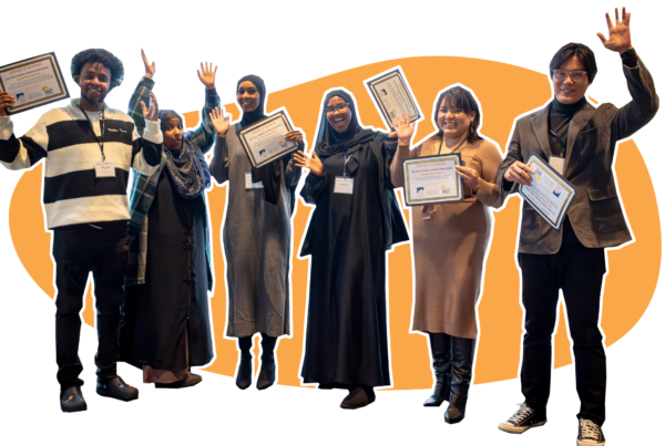 Six people smiling and standing with their hands and certificate of recognitions up