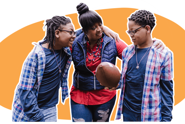 Mother with two teenagers, looking at a football